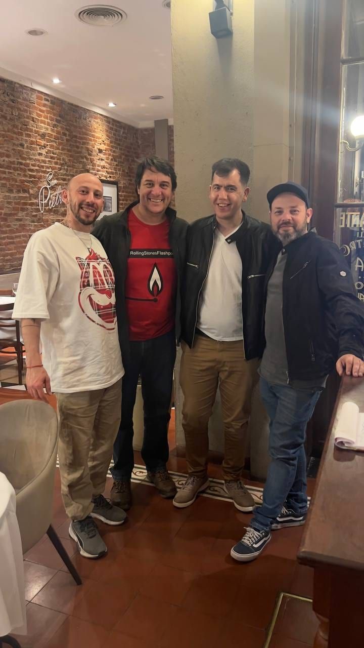 Four men standing together in a bar, posing for a photo